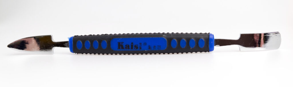 Kaisi dual-ended metal spudger with anti-slip grip, used for opening electronic devices in repair work.