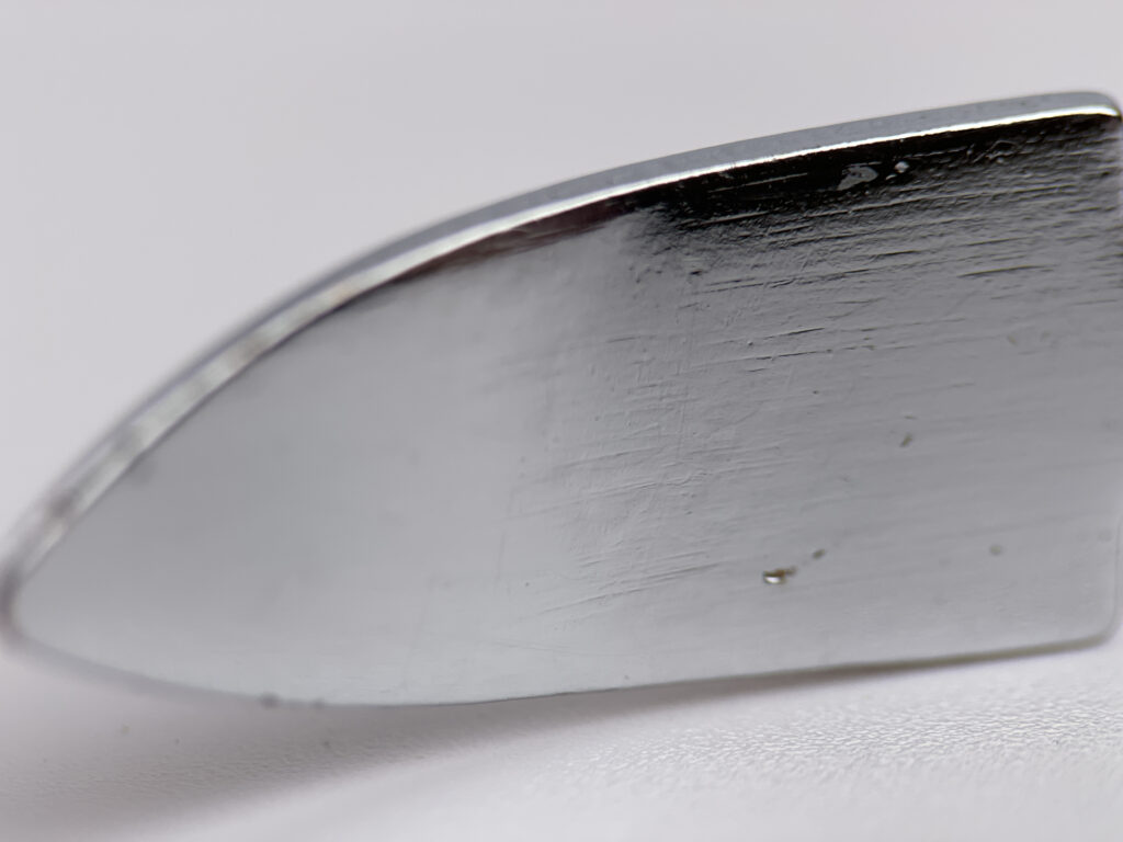 Close-up of OriGlam Metal Spudger Tip, wedge-shaped, metal tool for prying and scraping in DIY projects.