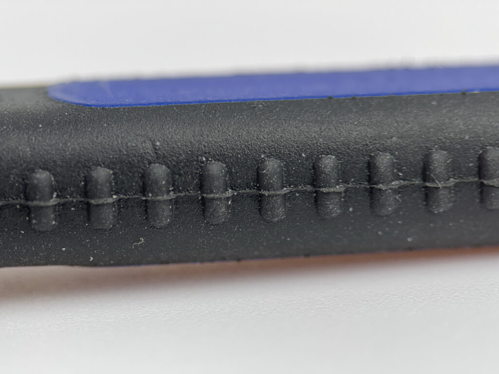 Macro photography of the rubber and plastic handle of an OriGlam spudger.