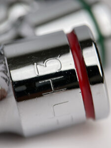 Close-up of a chrome socket bit with red color band and etched size marking, emphasizing clarity and color-coded identification.